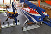 Two large RC airplanes secured for transport in trailer using Random Heli Gear Jacks